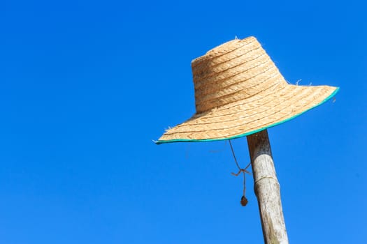 farmer's hat was hanged on bamboo and blue sky in rural ,Thailand