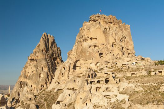 Ancient town and a castle of Uchisar dug from a mountains after sunrise, Cappadocia, Turkey