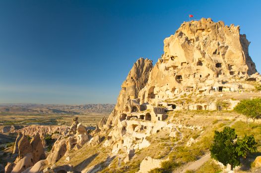 Ancient town and a castle of Uchisar dug from a mountains after sunrise, Cappadocia, Turkey