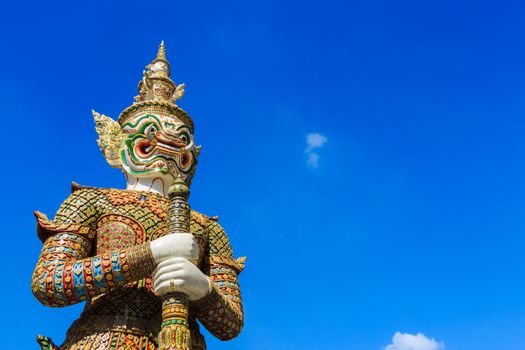 The statue of giant hold club and blue sky in Wat Phra Kaew ,Thailand