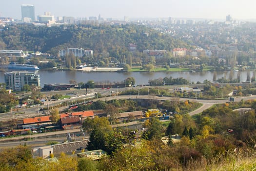 Photo shows a general city view with houses, trees and river.