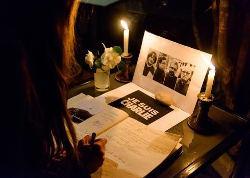 KATHMANDU, NEPAL - JANUARY 11, 2015: Woman signing the condolences book at  the Cafe des Arts gathering in tribute to the victims of the terrorist attacks in Paris.