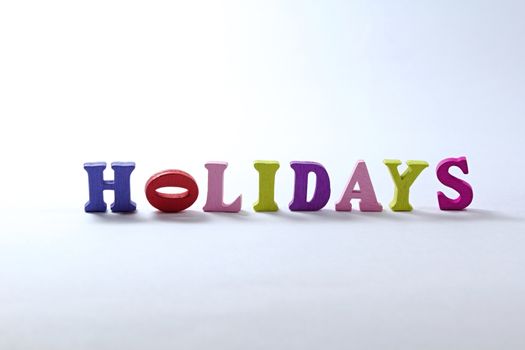 Photo shows detail of holidays sign on white background.