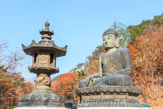 statue of buddha and colorful trees at shinheungsa temple in Seoraksan National Park in autumn ,Korea