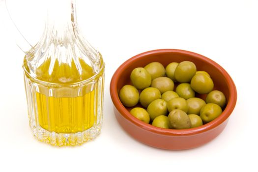 Rustic bowl of olives and olive oil on white background