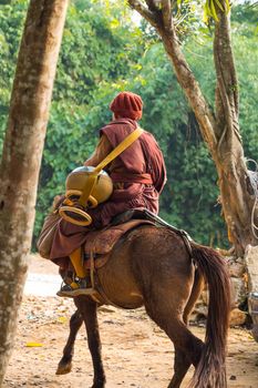 Buddhist monk with brown robe ride horse and ask for alms (Unseen in Thailand) at Chiangrai ,Thailand