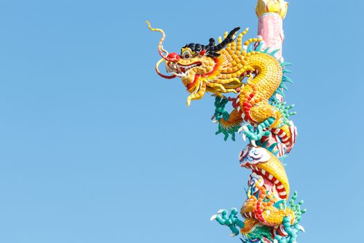 The old statue of gold dragon bind pillar and blue sky