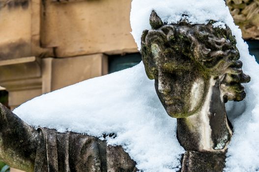 detail of a mourning sculpture on a cemetery