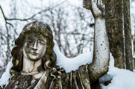 detail of a mourning sculpture on a cemetery