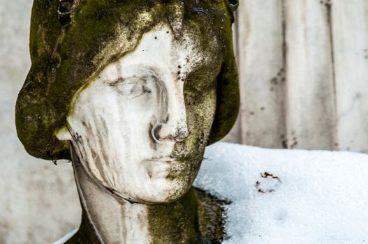 detail of a mourning sculpture on a cemetery