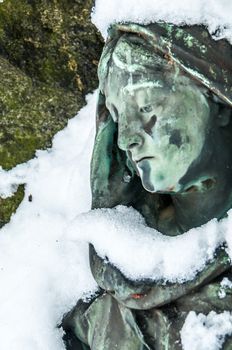 detail of a mourning sculpture on a cemetery