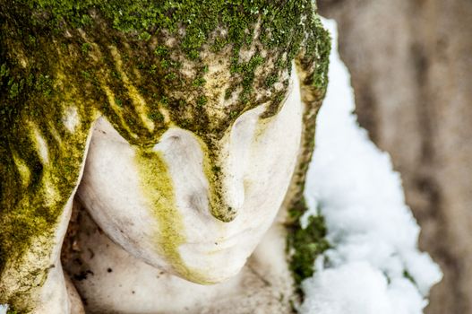 detail of a mourning sculpture on a cemetery