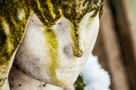 detail of a mourning sculpture on a cemetery