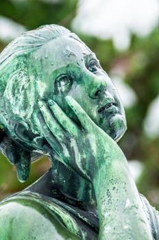 detail of a mourning sculpture on a cemetery