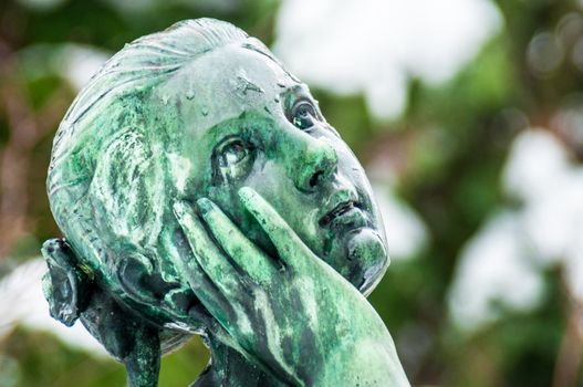 detail of a mourning sculpture on a cemetery