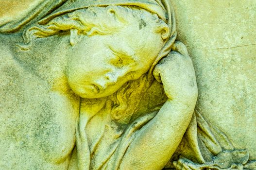 detail of a mourning sculpture on a cemetery