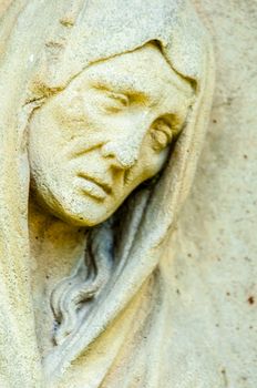 detail of a mourning sculpture on a cemetery