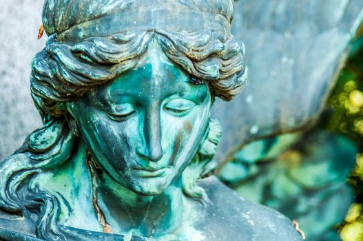 detail of a mourning sculpture on a cemetery