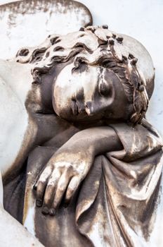 detail of a mourning sculpture on a cemetery