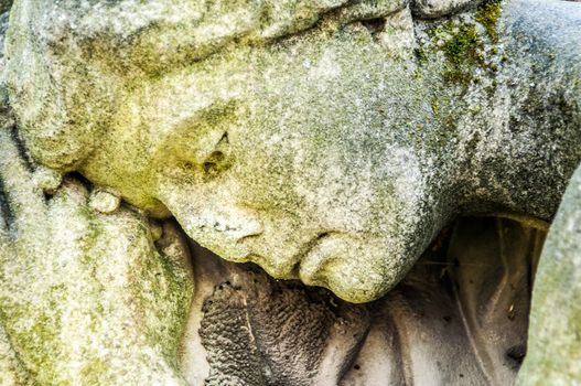 detail of a mourning sculpture on a cemetery