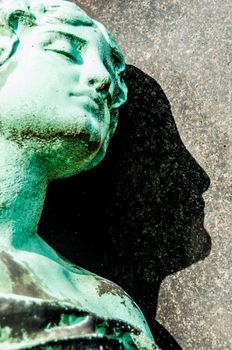 detail of a mourning sculpture on a cemetery