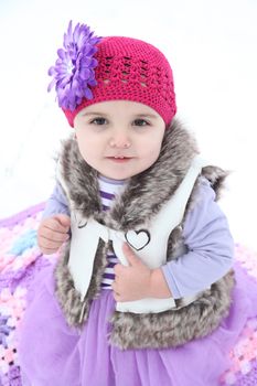 Little girl sitting outside on a snowy day