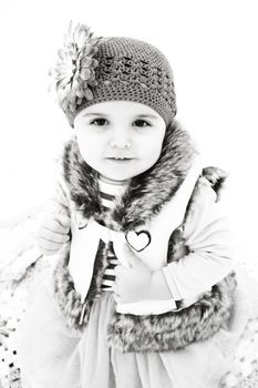 Little girl sitting outside in the snow