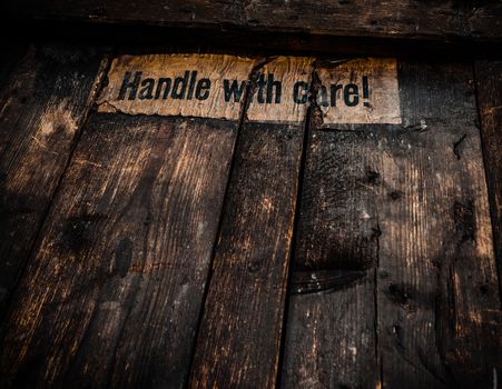 Grungy Filtered Handle WIth Care Sign On An Old Wooden Shipping Crate