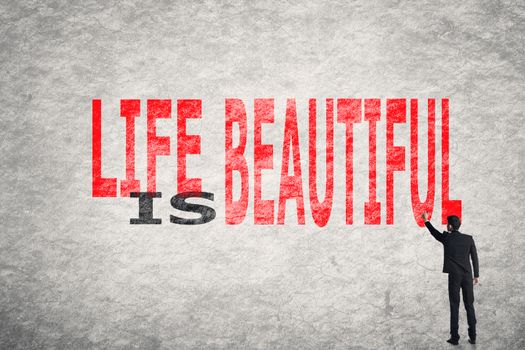 Asian businessman write text on wall, Life is Beautiful