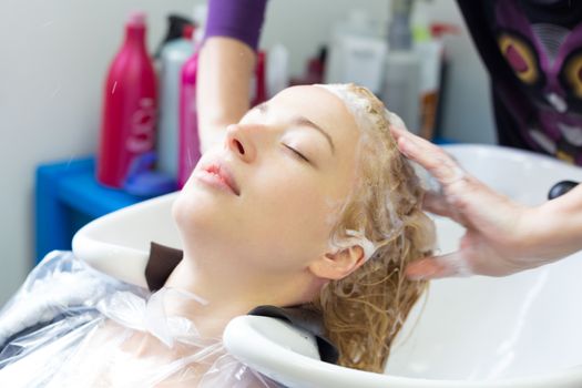 Hairdresser salon. Woman enjoying during hair washmassage.