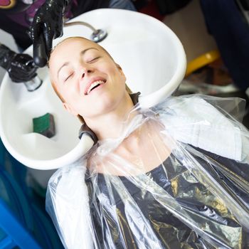 Hairdresser salon. Woman enjoying during hair wash.