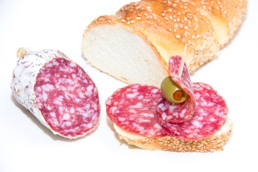 Bread with slices of salami on white background