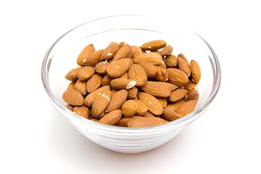Almonds in glass bowl on white background