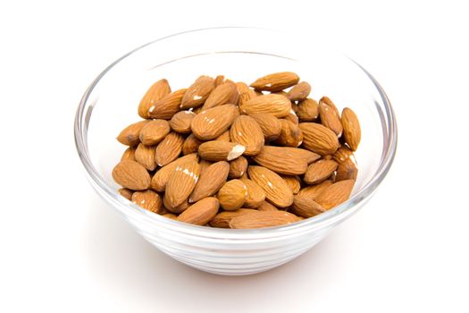 Almonds in glass bowl on white background
