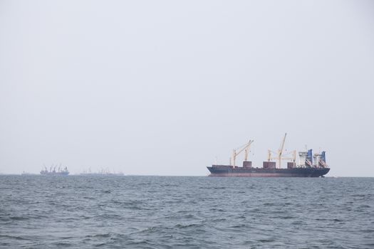 Large cargo ship Boats moored in the sea to make sense compared to the coast.