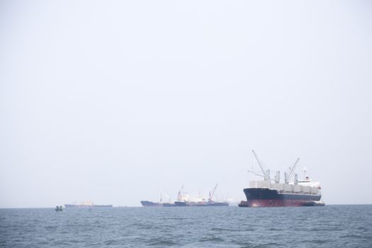 Large cargo ship Boats moored in the sea to make sense compared to the coast.