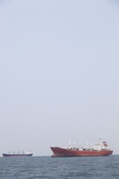 Large cargo ship Boats moored in the sea to make sense compared to the coast.