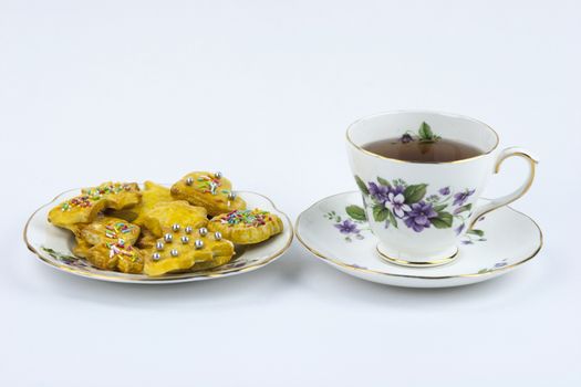 Isolated cup of english tea whit sweet and decored cookies