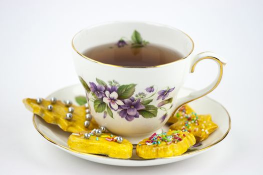 Isolated cup of english tea whit sweet and decored cookies