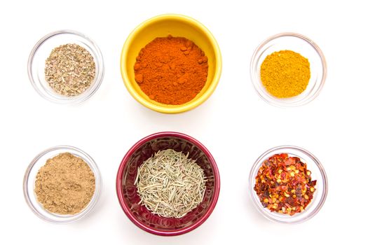 Bowls with spices viewed from above on white background
