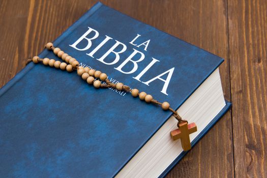 Bible on wooden table with rosary