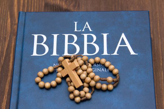 Bible with crucifix on wooden table