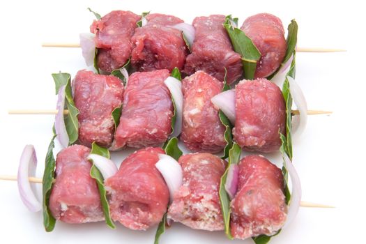 Skewers of meat on white background