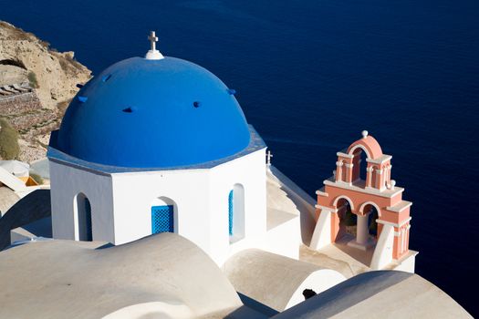 Blue domes and their bell tower in Oia. Santorini