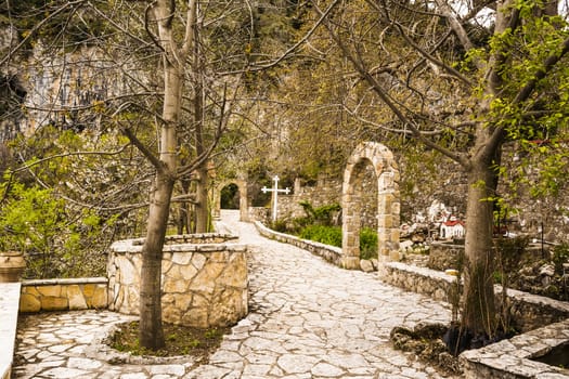 Rural Greek church entrance in a mountain with trees