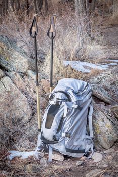 hiking concept - backpack and trekking poles in a rocky terrain