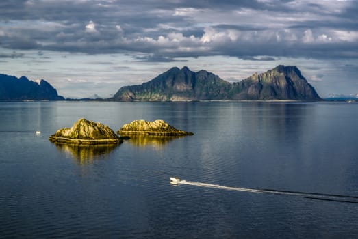 Picturesque view of Lofoten islands with speedboat on the ocean            
