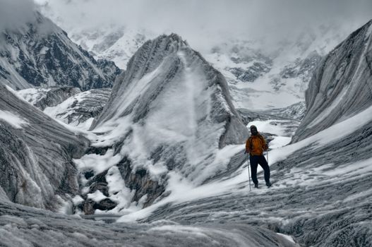 Adventurous hiker on Engilchek glacier in scenic Tian Shan mountain range in Kyrgyzstan