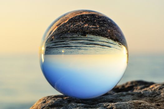 Glass ball on the boulder at the sea