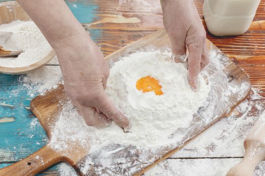 Hands kneading dough on board - flour and eggs